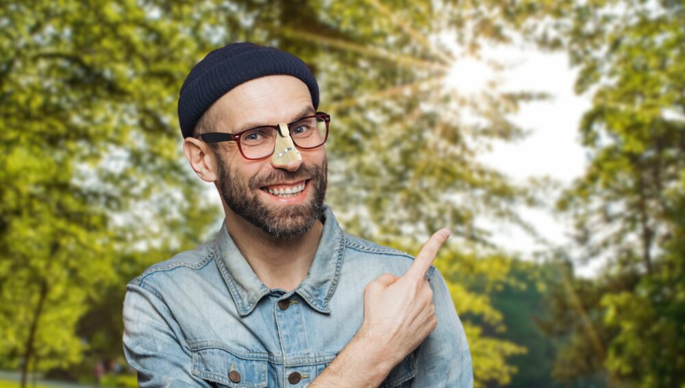 Man beschermt zijn neus met een neuskapje tegen de zon